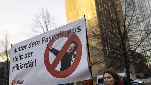 Protesters outside the WELT Economy Summit hold up a placard that reads Behind fascism is a billionaire, criticizing tech billionaire Elon Musk on January 27, 2025 in Berlin, Germany.  - Sputnik Africa