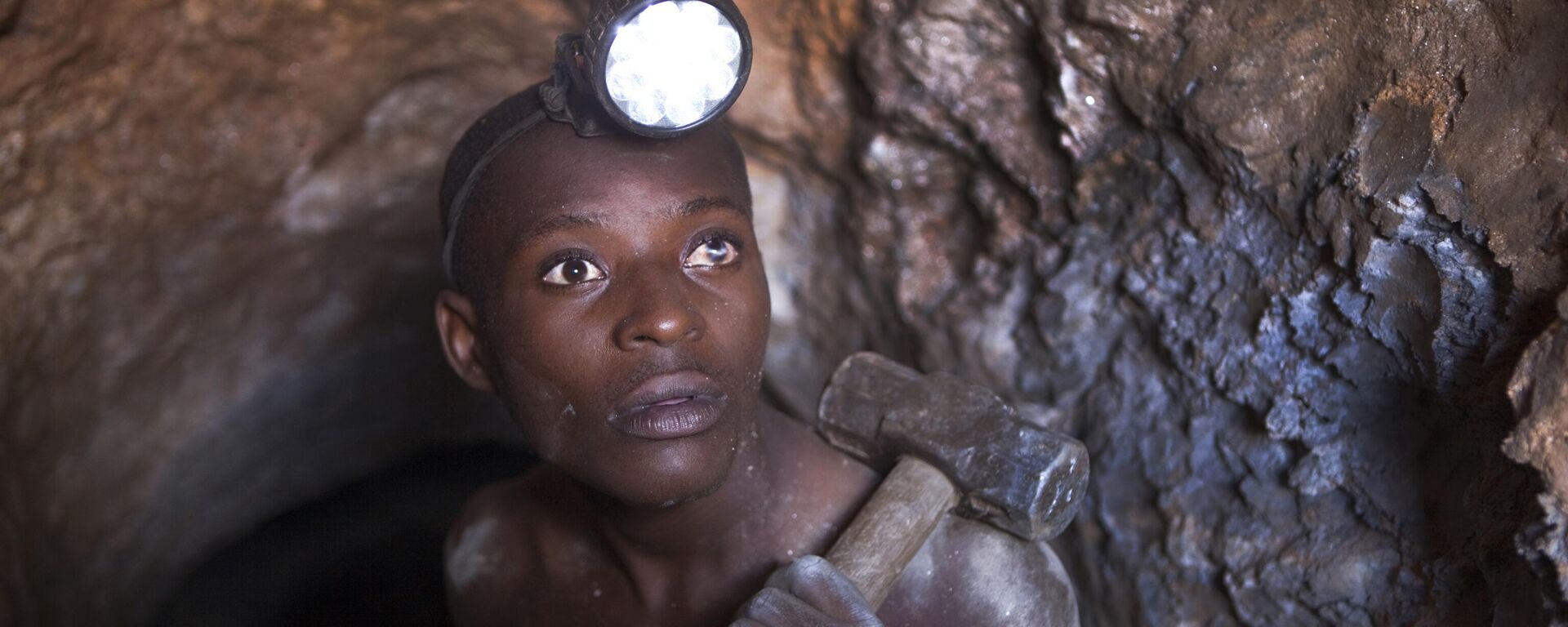 Nsinku Zihindula (25), who works 24-hour shifts, hammers at solid rock to find cassiterite ore at Szibira. Nsinku was blinded in his left eye by flying rock, but must continue to work in the dangerous tunnels to earn money to feed his wife and child.  - Sputnik Africa, 1920, 29.01.2025