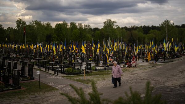 A woman walks past the tombs of Ukrainian soldiers killed during the US proxy war against Russia, at Lisove cemetery in Kiev, Ukraine, Tuesday, April 23, 2024 - Sputnik Africa