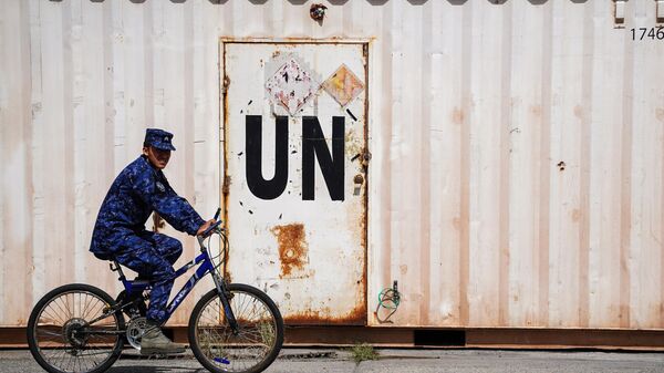 A soldier rides a bicycle next to a container with a UN label before deployment to Haiti as part of a UN Multinational Security Support Mission, in Ilopango. - Sputnik Africa