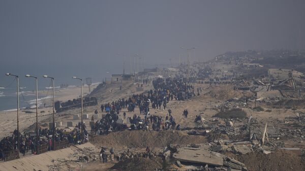 Displaced Palestinians walk on a road in central Gaza to return to their homes in the northern Gaza Strip, following the Israel-Hamas ceasefire deal, Friday, Jan. 31, 2025. - Sputnik Africa