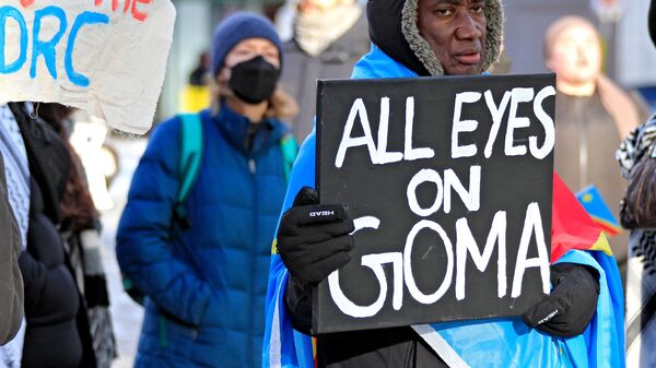 A protestor holds a sign at a rally at Yonge-Dundas Square to bring attention to the humanitarian crisis and regional instability in the Democratic Republic of Congo, where multiple armed groups, including the M23 rebels, are active, in Toronto, Canada, on February 1, 2025.  - Sputnik Africa