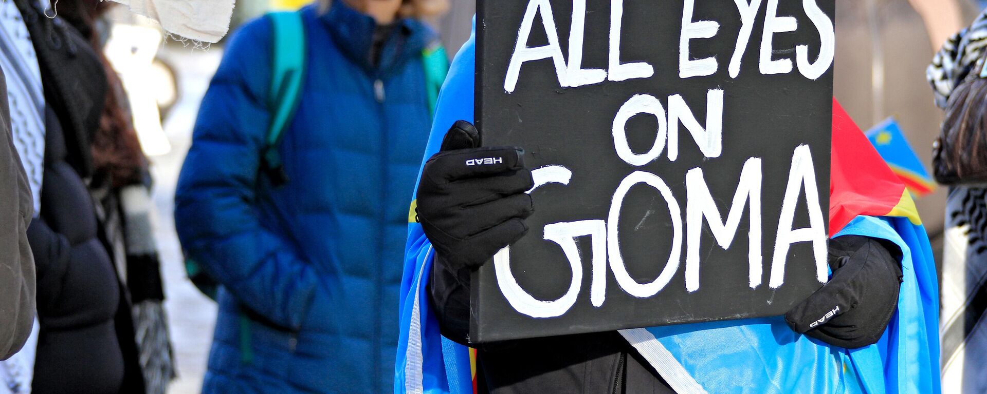 A protestor holds a sign at a rally at Yonge-Dundas Square to bring attention to the humanitarian crisis and regional instability in the Democratic Republic of Congo, where multiple armed groups, including the M23 rebels, are active, in Toronto, Canada, on February 1, 2025.  - Sputnik Africa, 1920, 06.02.2025