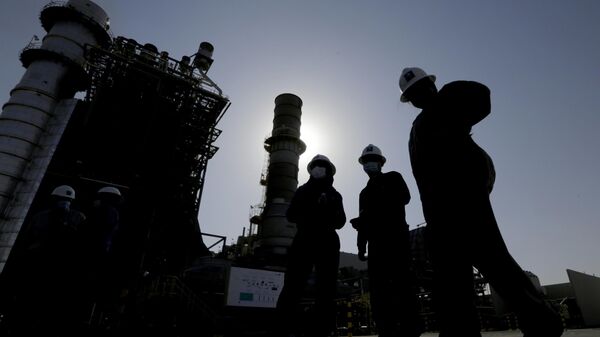 Saudi Aramco engineers walk in front of a gas turbine generator at Khurais oil field during a tour for journalists, outside of Riyadh, Saudi Arabia on June 28, 2021.  - Sputnik Africa