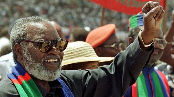 Le Président namibien Sam Nujoma salue ses partisans lors d'un rassemblement à Windhoek, en Namibie, le 28 novembre 1999, alors qu'il faisait campagne pour un second mandat de cinq ans. Après des décennies de lutte révolutionnaire et trois mandats présidentiels, Nujoma est prêt à se retirer. (AP Photo / Themba Hadebe) - Sputnik Africa