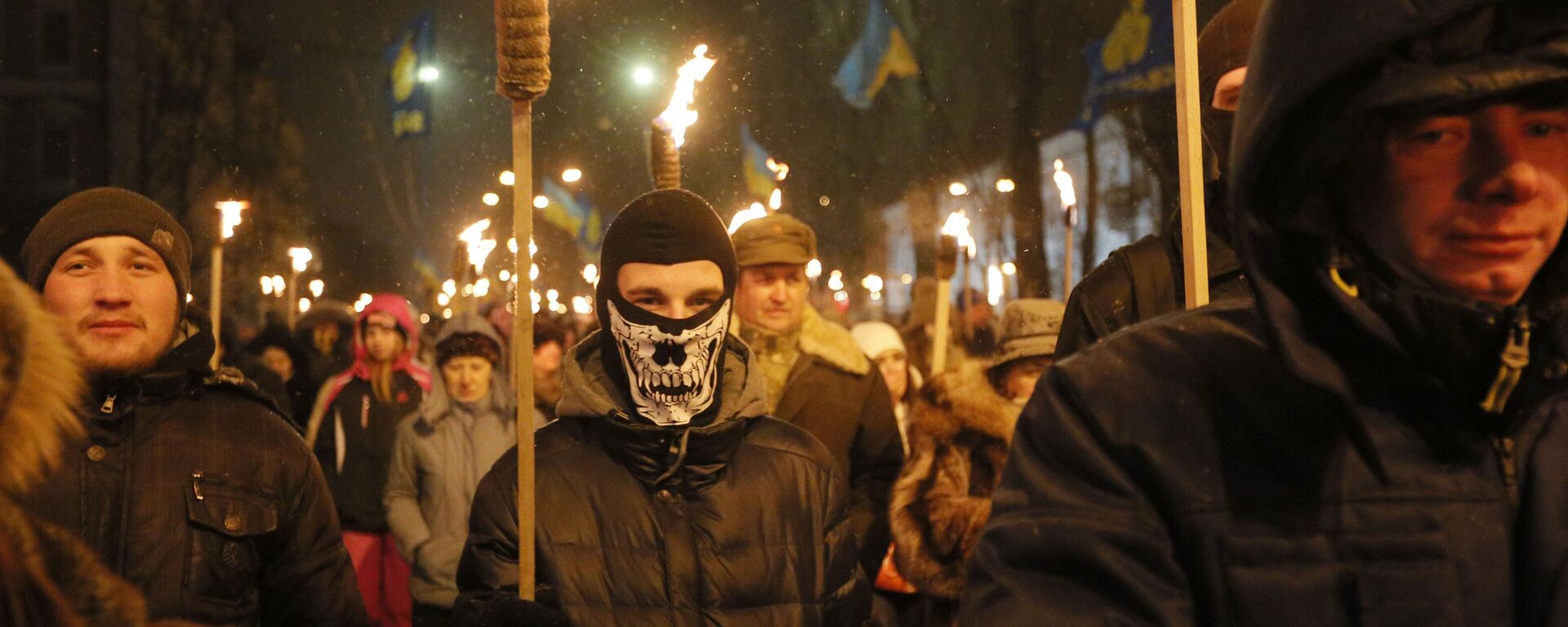 Ukrainian Neo-Nazis carry burning torches during a rally in downtown Kiev, Ukraine, Friday, Jan. 1, 2016, to commemorate the 1909 birth anniversary of notorious Ukrainian political activist and national independence leader Stepan Bandera - Sputnik Africa, 1920, 09.02.2025