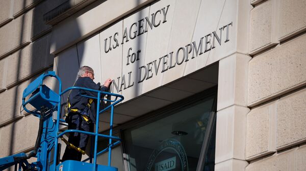 WASHINGTON, DC - FEBRUARY 07: A worker removes the US Agency for International Development sign on their headquarters on February 07, 2025 in Washington, DC.  - Sputnik Africa