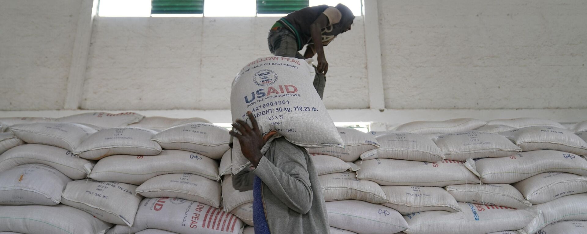 MEKELE, ETHIOPIA - JUNE 16: Aid workers move bags of yellow lentils that are part of athree-piece Full Package to be distributed to residents of Geha subcity at an aid operation run by USAID, Catholic Relief Services and the Relief Society of Tigray on June 16, 2021 in Mekele, Ethiopia. - Sputnik Africa, 1920, 13.02.2025