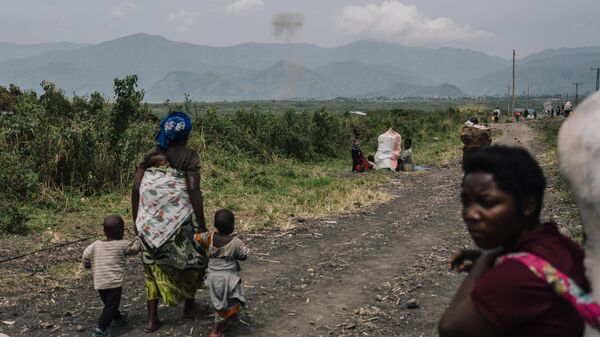 Displaced civilians watch the smoke of a detonated munition outside the city of Goma on February 12, 2025, in Goma, Democratic Republic of Congo. - Sputnik Africa