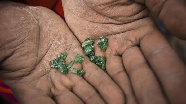 An African man holds gemstones in his hands. - Sputnik Africa