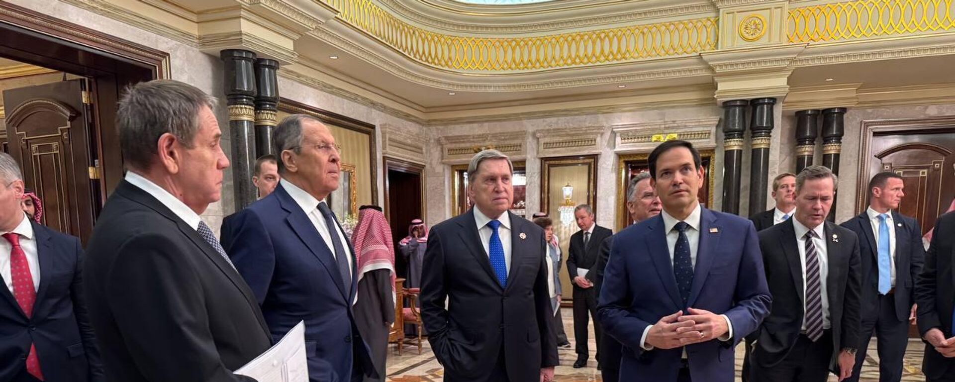 Russian Foreign Minister Sergey Lavrov (C) and Russian President Vladimir Putin's Foreign Policy Advisor Yuri Ushakov (2nd R) chat with Saudi Arabian officials, following meeting between Russia and the United States in Ukraine, in Riyadh, Saudi Arabia, on February 18, 2025. The talks aimed at improving relations between the two nations and addressing the conflict in Ukraine.  - Sputnik Africa, 1920, 19.02.2025