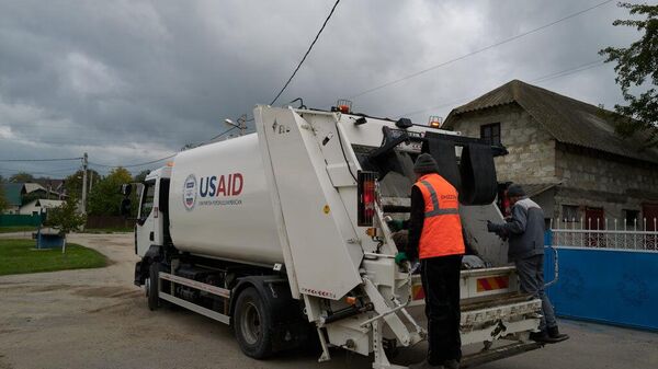 Workers collect waste using a garbage truck donated by the US Agency for International Development (USAID) on October 17, 2024 in Budesti, Moldova. - Sputnik Africa