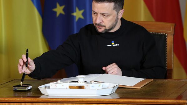 Volodymyr Zelensky signs a guest book as he visits German President Frank-Walter Steinmeier at Bellevue presidential palace on May 14, 2023 in Berlin, Germany. - Sputnik Africa