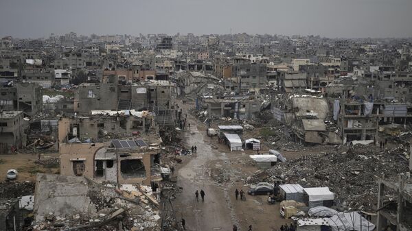 Palestinians walk surrounded by the rubble of destroyed homes and building in the Zeitoun neighborhood of Gaza City, Friday, March 7, 2025. - Sputnik Africa