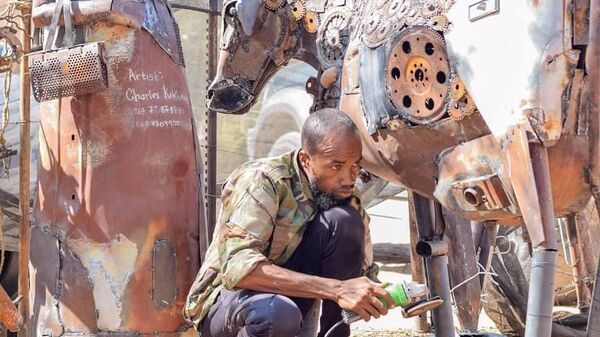 Botswanan artist Charles Kakomee-Tjeja and his artwork Omukaendu o Tjitenda (left), which translates as a metallic woman. - Sputnik Africa