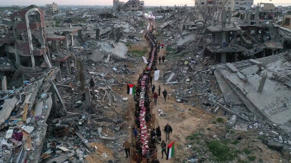 An aerial view of hundreds of Palestinians in the Tel al-Hawa neighbourhood breaking their Iftar at a large table set amidst the rubble in the ruined streets in Gaza City, Gaza on March 09, 2025. - Sputnik Africa