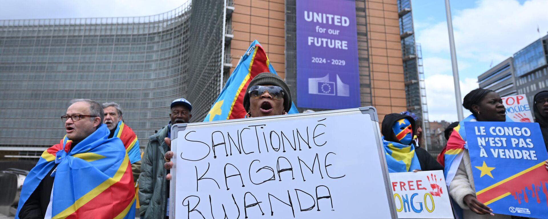 A group of demonstrators blaming Rwanda for the conflict in eastern Democratic Republic of Congo (DRC) gather with placards in Schuman Roundabout square in front of European Commission headquarters to call on the EU to impose sanctions against Rwanda in Brussels, Belgium on March 17, 2025.  - Sputnik Africa, 1920, 18.03.2025