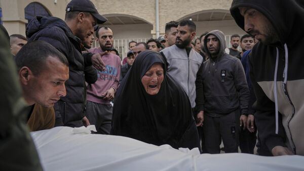 A woman reacts over the body of a person killed during overnight Israeli army airstrikes across the Gaza Strip, at the Al-Ahli hospital in Gaza City, Tuesday, March 18, 2025. - Sputnik Africa