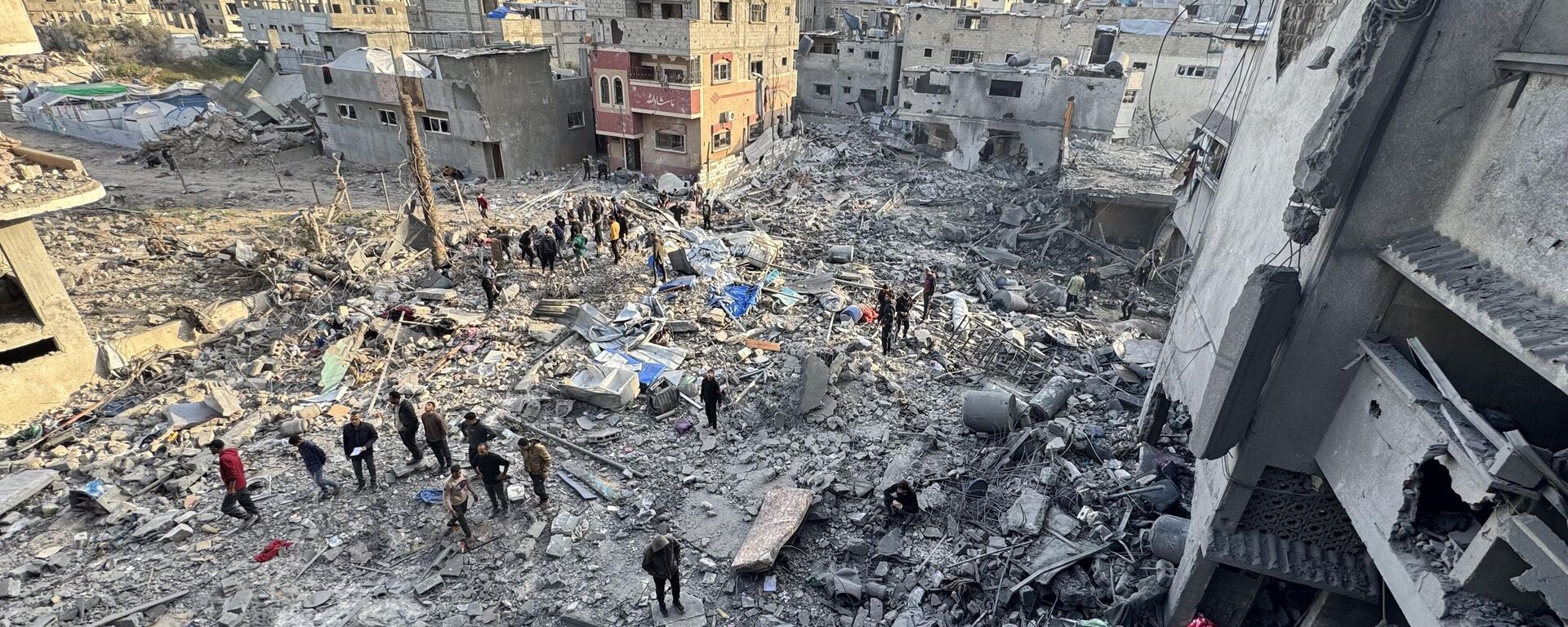 Search and rescue operations are underway amidst the rubble of the collapsed structure after an airstrike on a building belonging to the Qraiqea family in the Shujaiya neighborhood, east of Gaza City, Gaza on March 18, 2025. - Sputnik Africa, 1920, 19.03.2025