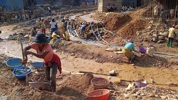 Workers, including women and children, work in a cobalt mine through small-scale and non-corporate mining activities referred to as artisanal mining, carried out under very poor conditions, without any precautions and any control by any authority in the Mwenga territory of South Kivu province in Democratic Republic of Congo on July 14, 2023.  - Sputnik Africa