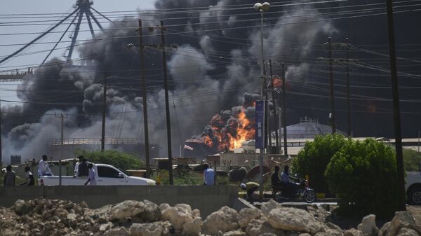 De la fumée s'élève après que des frappes de drones des Forces de soutien rapide paramilitaires ont ciblé le port nord de la ville de Port-Soudan, au Soudan, sur la mer Rouge, le mardi 6 mai 2025. (AP Photo) - Sputnik Afrique