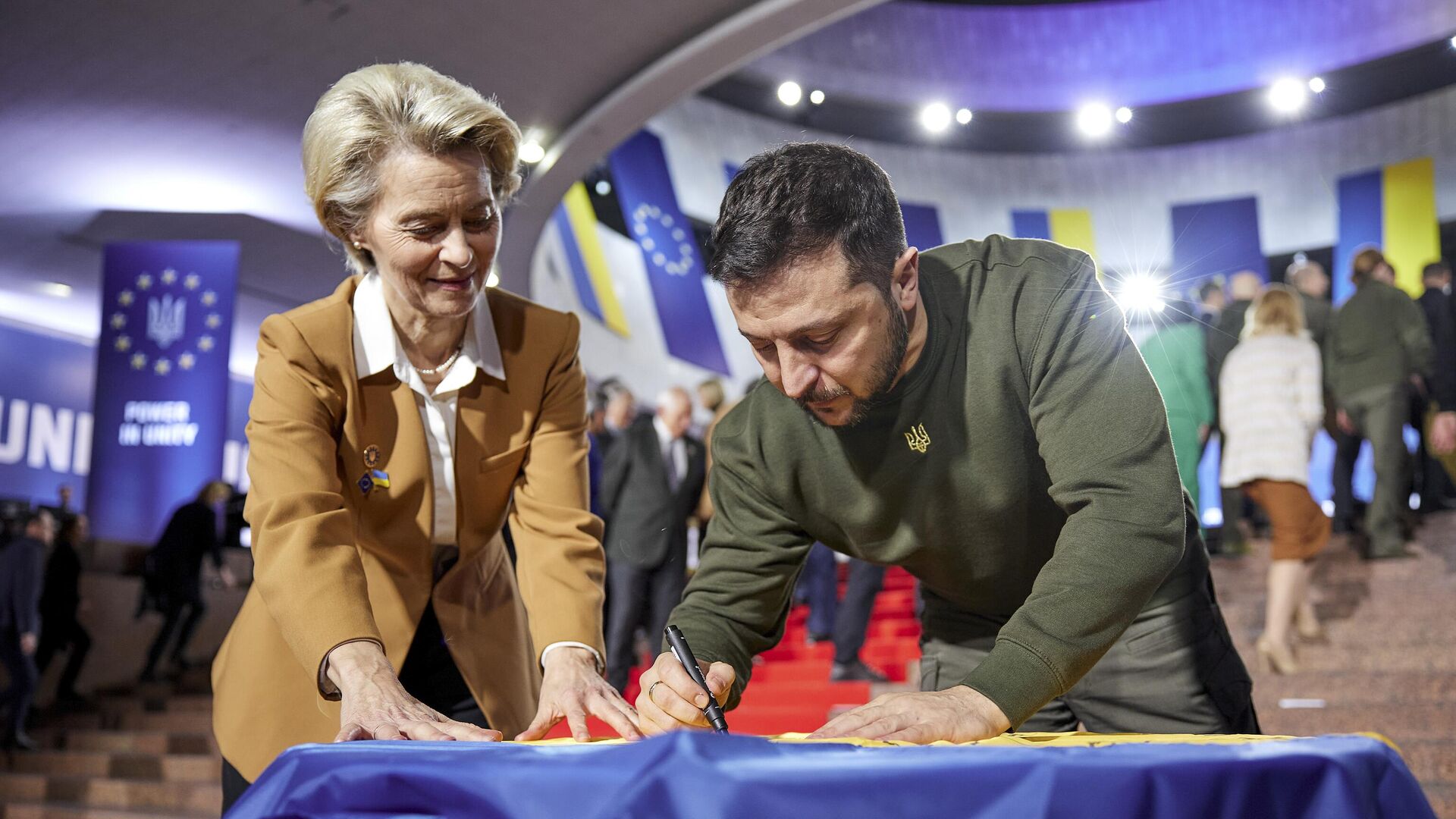 Ukrainian President Volodymyr Zelenskyy, right, and European Commission President Ursula von der Leyen write their wishes on a Ukrainian flag during the EU-Ukraine summit in Kyiv Ukrainian President Volodymyr Zelenskyy, right, and European Commission President Ursula von der Leyen write their wishes on a Ukrainian flag during the EU-Ukraine summit in Kyiv - Sputnik Africa, 1920, 08.05.2025