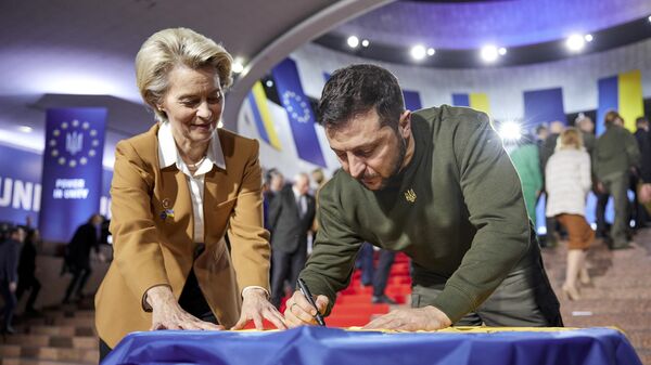 Ukrainian President Volodymyr Zelenskyy, right, and European Commission President Ursula von der Leyen write their wishes on a Ukrainian flag during the EU-Ukraine summit in Kyiv - Sputnik Africa