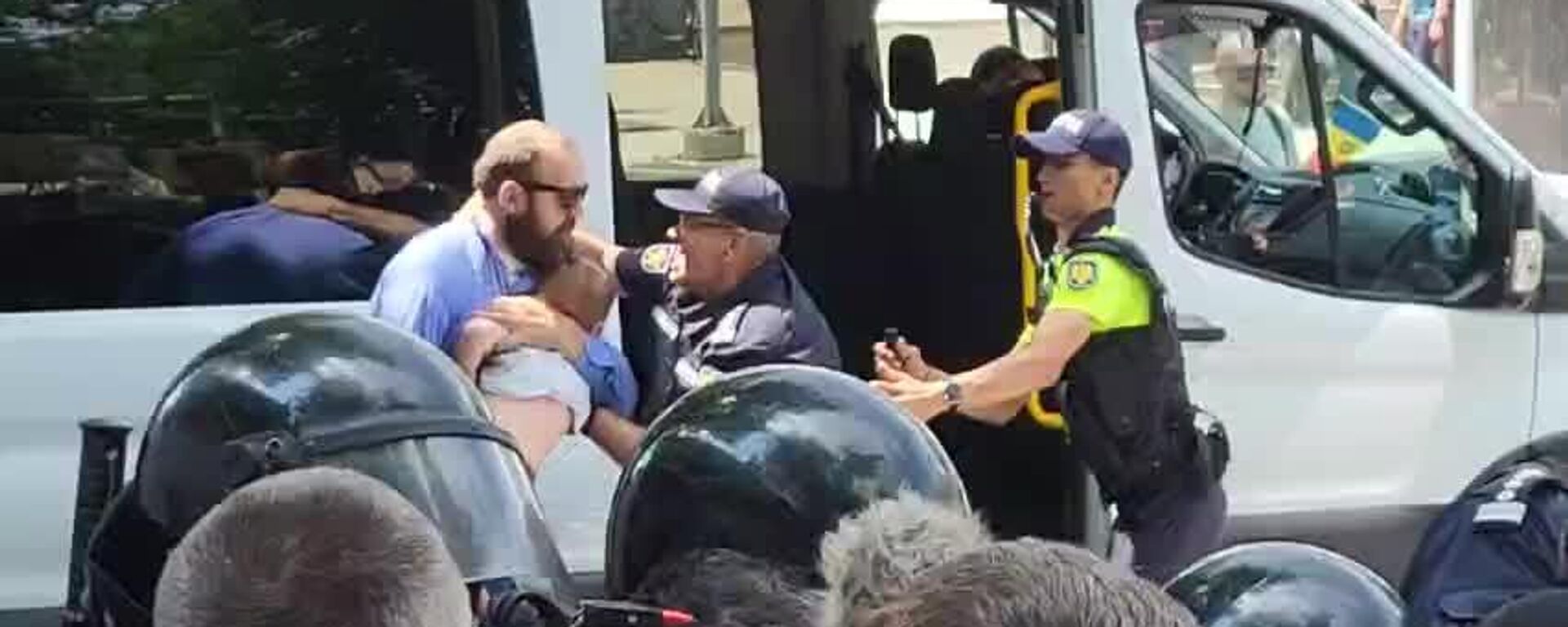 The man carrying the child was roughly pushed onto the bus by the Moldovan police - Sputnik Africa, 1920, 15.06.2025