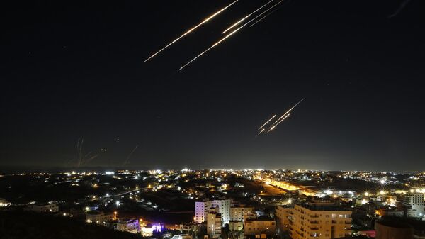 Missiles fired from Iran are seen streaking across the skies over the city of Hebron in the West Bank on June 18, 2025.  - Sputnik Africa