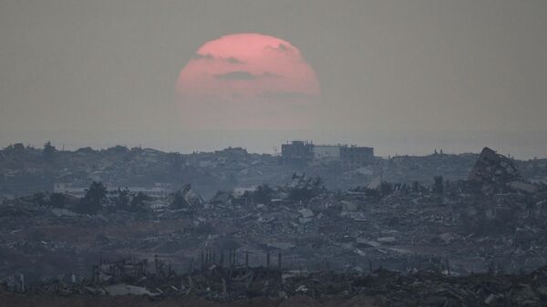 The sun sets behind buildings destroyed during Israeli ground and air operations in the northern Gaza Strip, as seen from southern Israel, Aug. 8, 2025 - Sputnik Africa