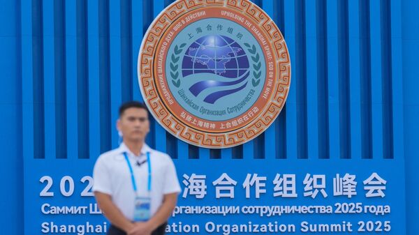 A security guard stands near the logo of Shanghai Cooperation Organization (SCO) member states outside the venue in Tianjin, China , Saturday, Aug. 30, 2025. - Sputnik Africa
