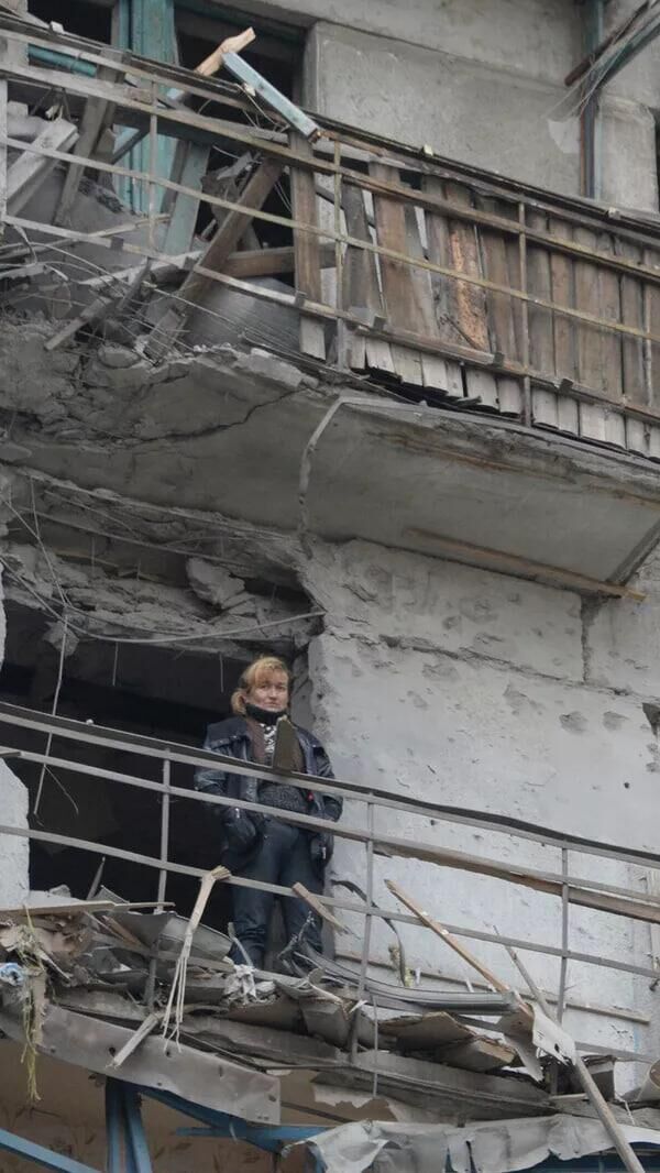 A woman on the balcony of a house bombed by the Ukrainian army. A woman on the balcony of a house bombed by the Ukrainian army. - Sputnik Africa