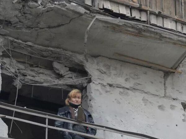 Une femme sur le balcon d'une maison bombardée par l'armée ukrainienne. - Sputnik Afrique