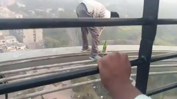 À NE PAS IMITER: un acrobate indien réalise un équilibre sur la tête, perché sur des bouteilles de bière, à 86m de hauteur - Sputnik Afrique
