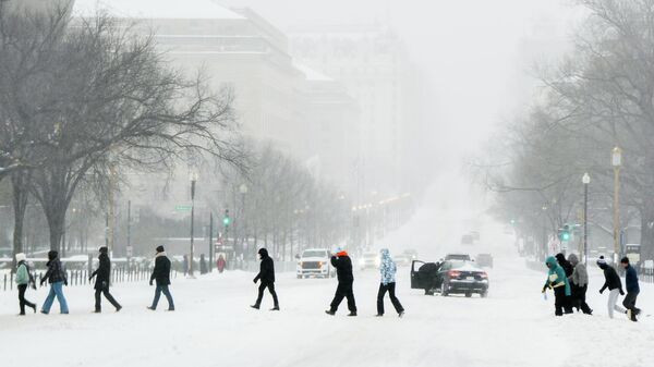 People cross a street during a snowstorm, Sunday, Jan. 25, 2026, in Washington - Sputnik Africa