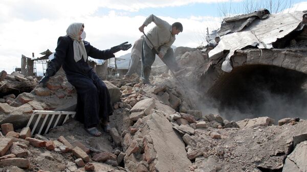 Мужчина и женщина осматривают завалы в деревне Хейдарабад, разрушенной землетрясением 2 апреля 2006 года - Sputnik Africa