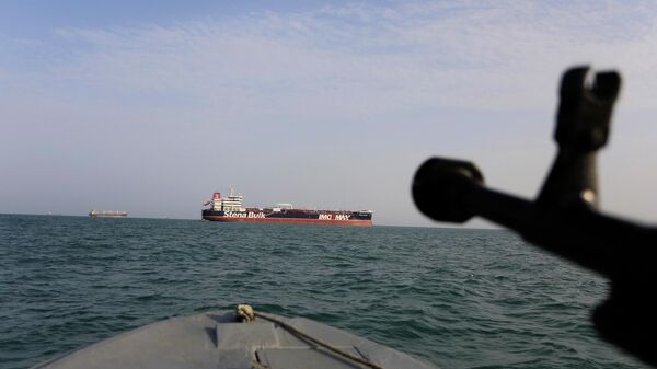In this Sunday, July 21, 2019 photo, a speedboat of Iran's Revolutionary Guard trains a weapon toward the British-flagged oil tanker Stena Impero, which was seized in the Strait of Hormuz on Friday by the Guard, in the Iranian port of Bandar Abbas. Global stock markets were subdued Monday while the price of oil climbed as tensions in the Persian Gulf escalated after Iran's seizure of a British oil tanker on Friday.  - Sputnik Africa