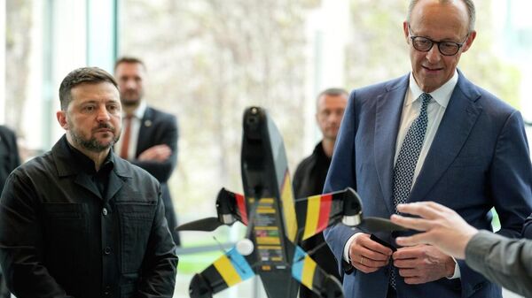 German chancellor Friedrich Merz and Ukraine's Volodymyr Zelensky watching a presentation of drones made in German-Ukrainian cooperation in Berlin Germany, Tuesday, April 14, 2026. - Sputnik Africa