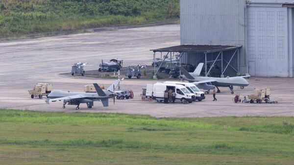 Des équipes au sol de l'armée américaine travaillent autour de drones MQ-9 Reaper de l'US Air Force sur le tarmac de l'ancienne base navale de Roosevelt Roads à Ceiba, Porto Rico, le 29 avril 2026. REUTERS/Ricardo Arduengo - Sputnik Afrique