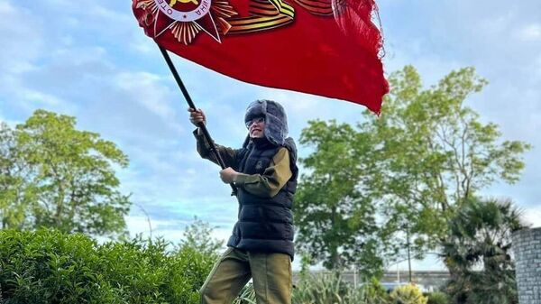A boy waving a modern Victory Day banner in the United Kingdom - Sputnik Afrique