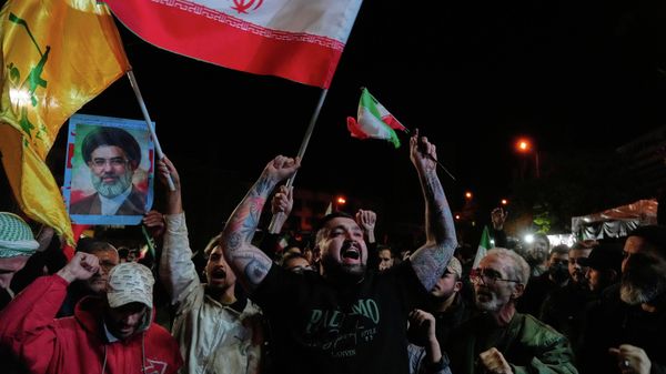 Iranians chant slogans as they hold Iranian flags and a poster of the Supreme Leader Ayatollah Mojtaba Khamenei in a gathering after announcement of a two-week ceasefire in the war with the United States and Israel, at the Enqelab-e-Eslami, or Islamic Revolution, Square, in Tehran, Iran, Wednesday, April 8, 2026.  - Sputnik Afrique