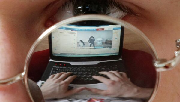 Житель Казани смотрит онлайн трансляцию на ноутбуке в день выборов президента РФ. - Sputnik Afrique