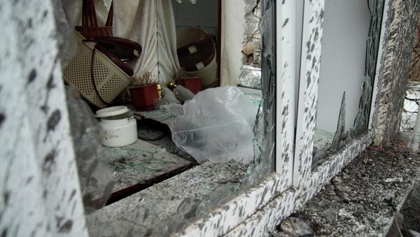 Окно с выбитыми стеклами в разрушенном в результате обстрела частном доме в Петровском районе Донецка - Sputnik Afrique