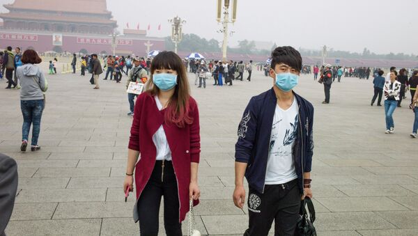 Un couple aux masques respiratoires sur la Place Tiananmen à Pékin - Sputnik Afrique
