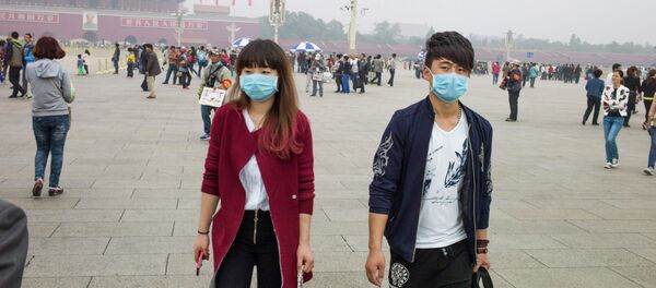 Un couple aux masques respiratoires sur la Place Tiananmen à Pékin - Sputnik Afrique