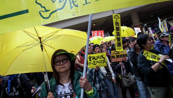 Thousands of pro-democracy protesters hold up yellow umbrellas, symbols of the Occupy Central movement, and banners reading I want real universal suffrage during a march in the streets to demand universal suffrage in Hong Kong February 1, 2015 - Sputnik Afrique