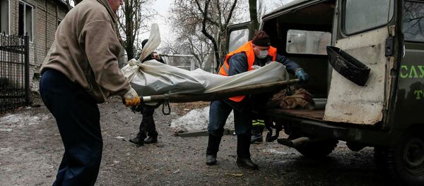 Men load the body of a victim of shelling into a vehicle at a site hit by shelling in Donetsk, eastern Ukraine, February 1, 2015 - Sputnik Afrique