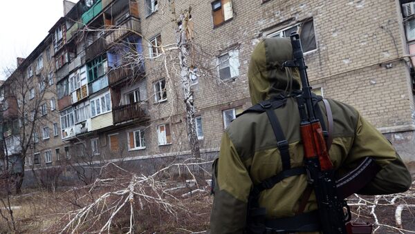 A pro-Russian fighter looks at a building on February 1, 2015 after it was damaged by shelling the day before in Makiivka - Sputnik Afrique