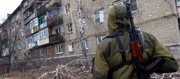 A pro-Russian fighter looks at a building on February 1, 2015 after it was damaged by shelling the day before in Makiivka - Sputnik Afrique