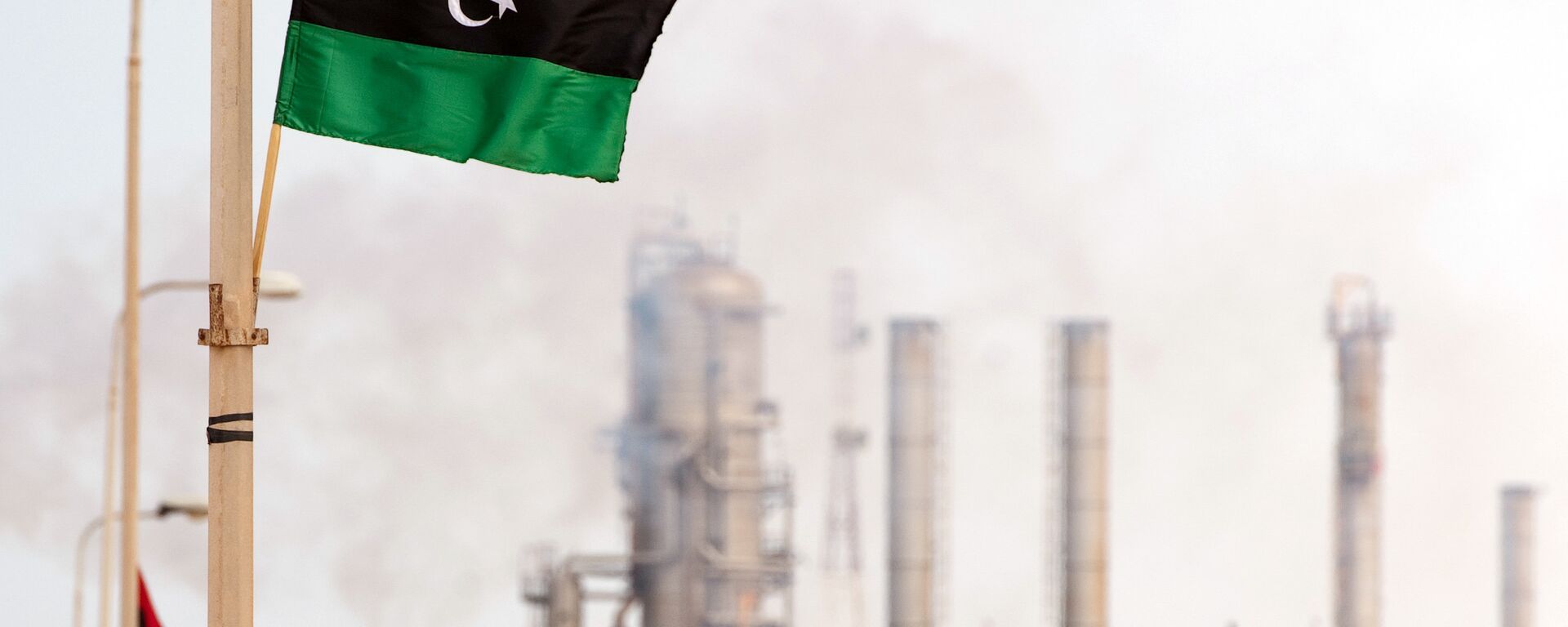 Le drapeau libyen flotte devant une raffinerie de pétrole - Sputnik Afrique, 1920, 18.12.2020